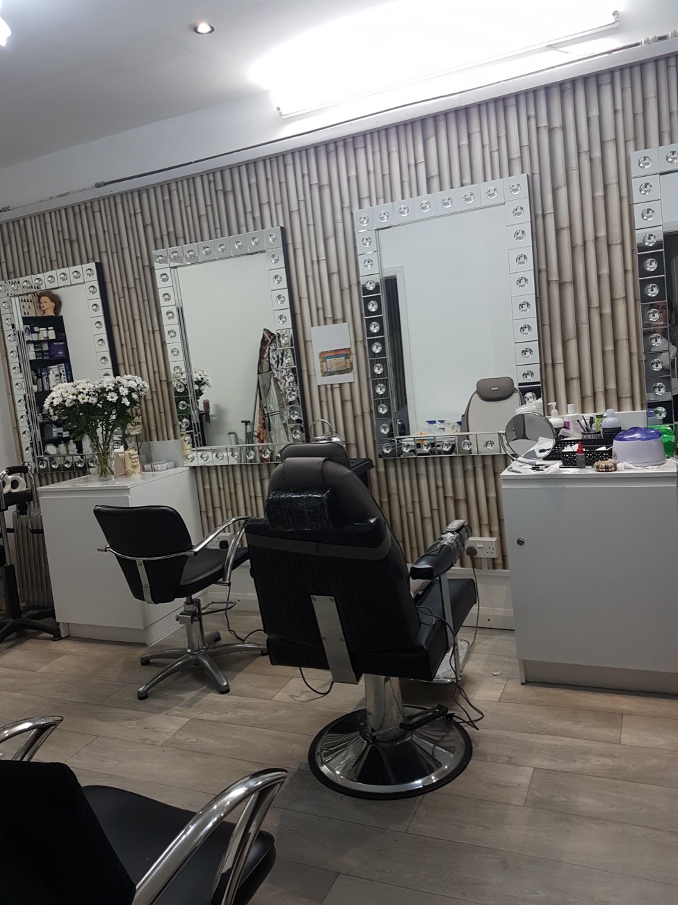 Inside the salon — styling stations and bright bulb-lit mirrors